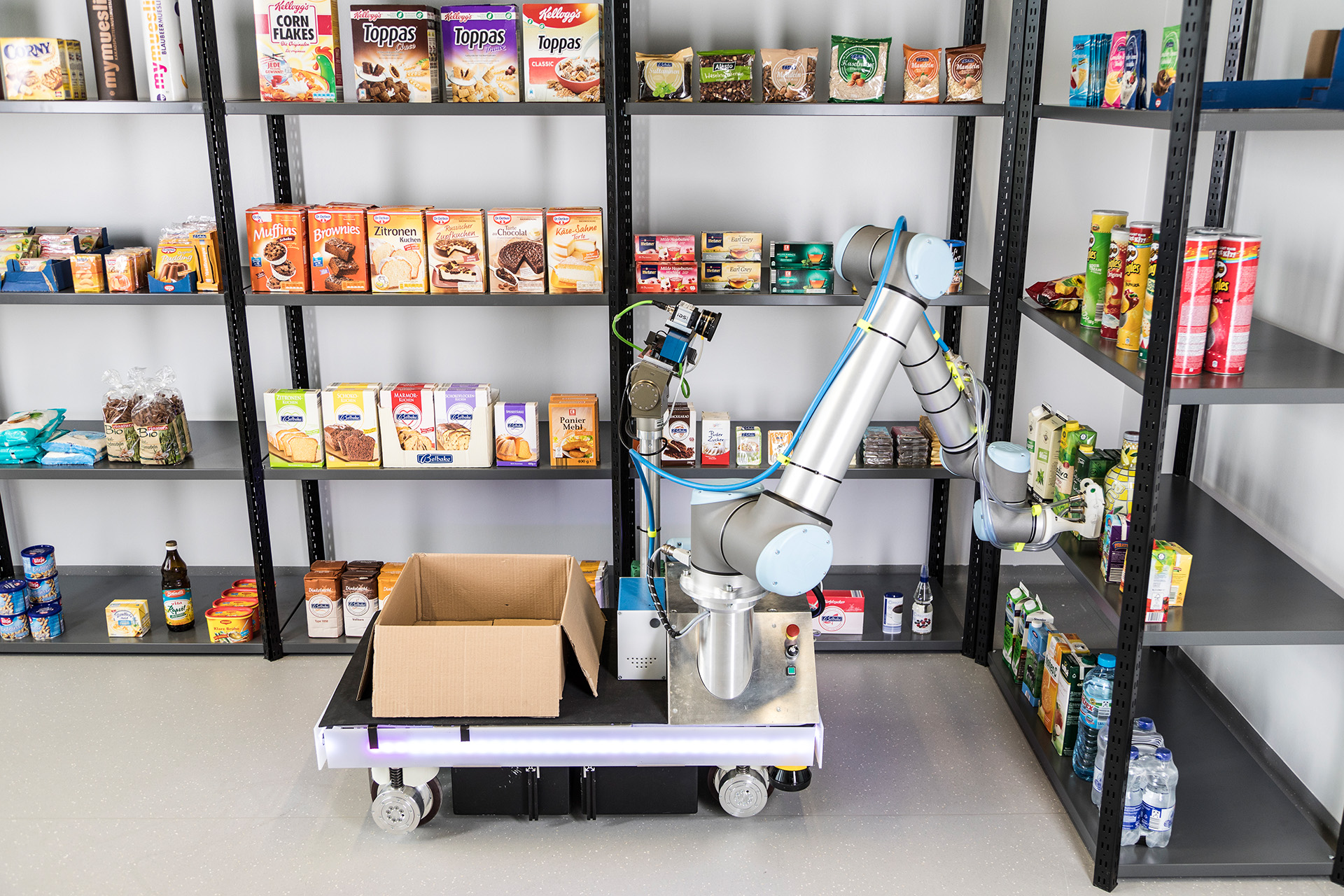 Roboter greift Ware aus einem Regal und packt sie in eine Kiste