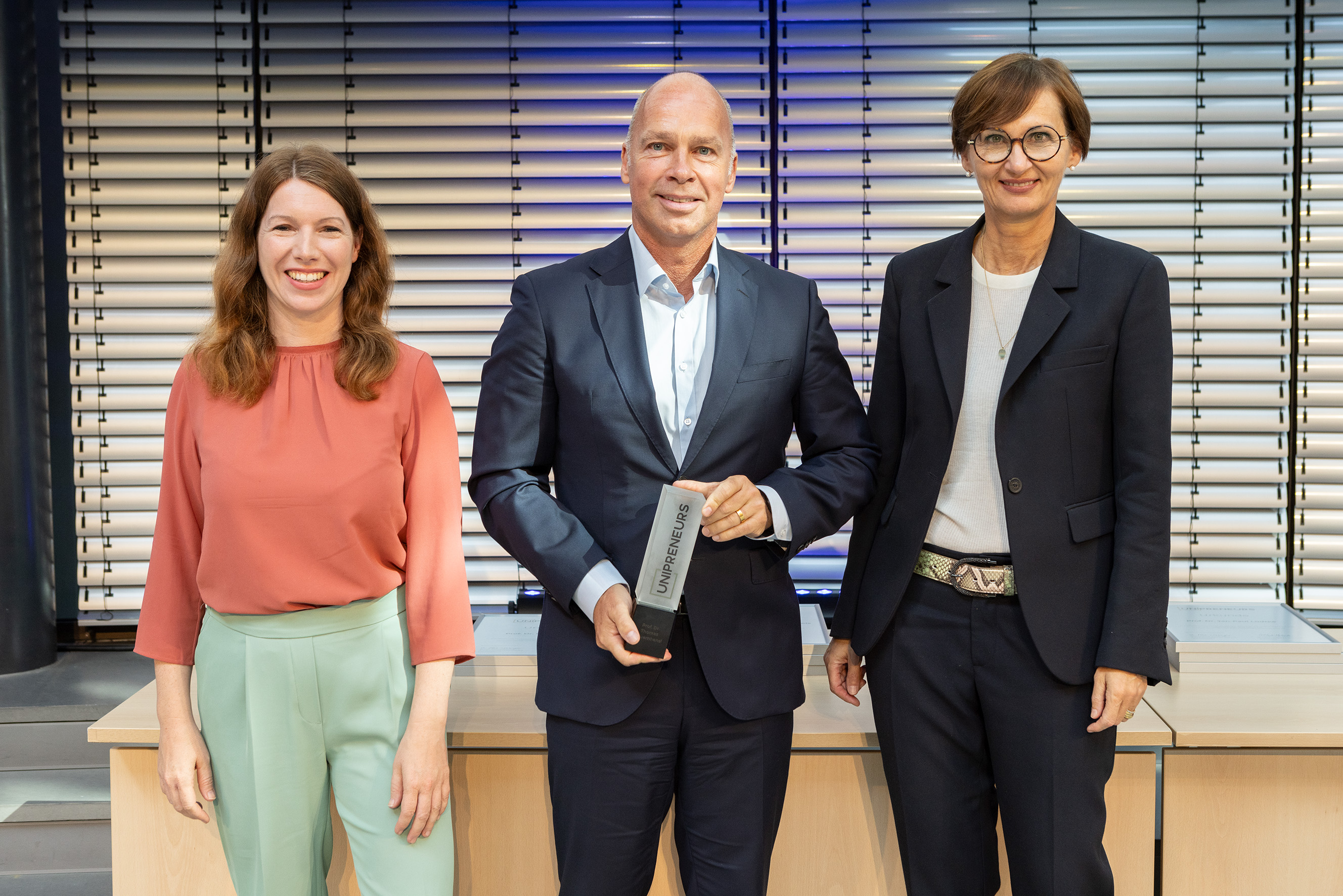 Thomas Bauernhansl mit der Auszeichnung der Initiative UNIPRENEURS. Ebenfalls auf dem Foto: Anna Christmann, MdB, und Bundesforschungsministerin Bettina Stark-Watzinger.