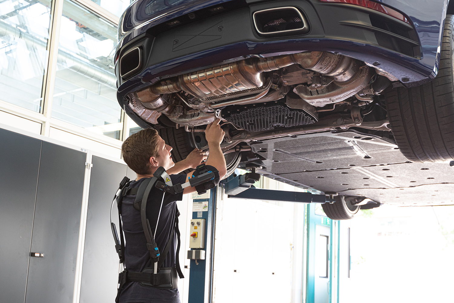 Mechaniker bei der Überkopfarbeit in einer Autowerkstatt