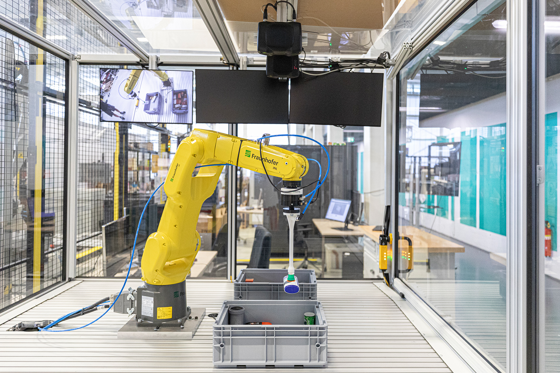 Ein Roboter greift verschiedene Komsumprodukte und legt sie in einer Kiste ab