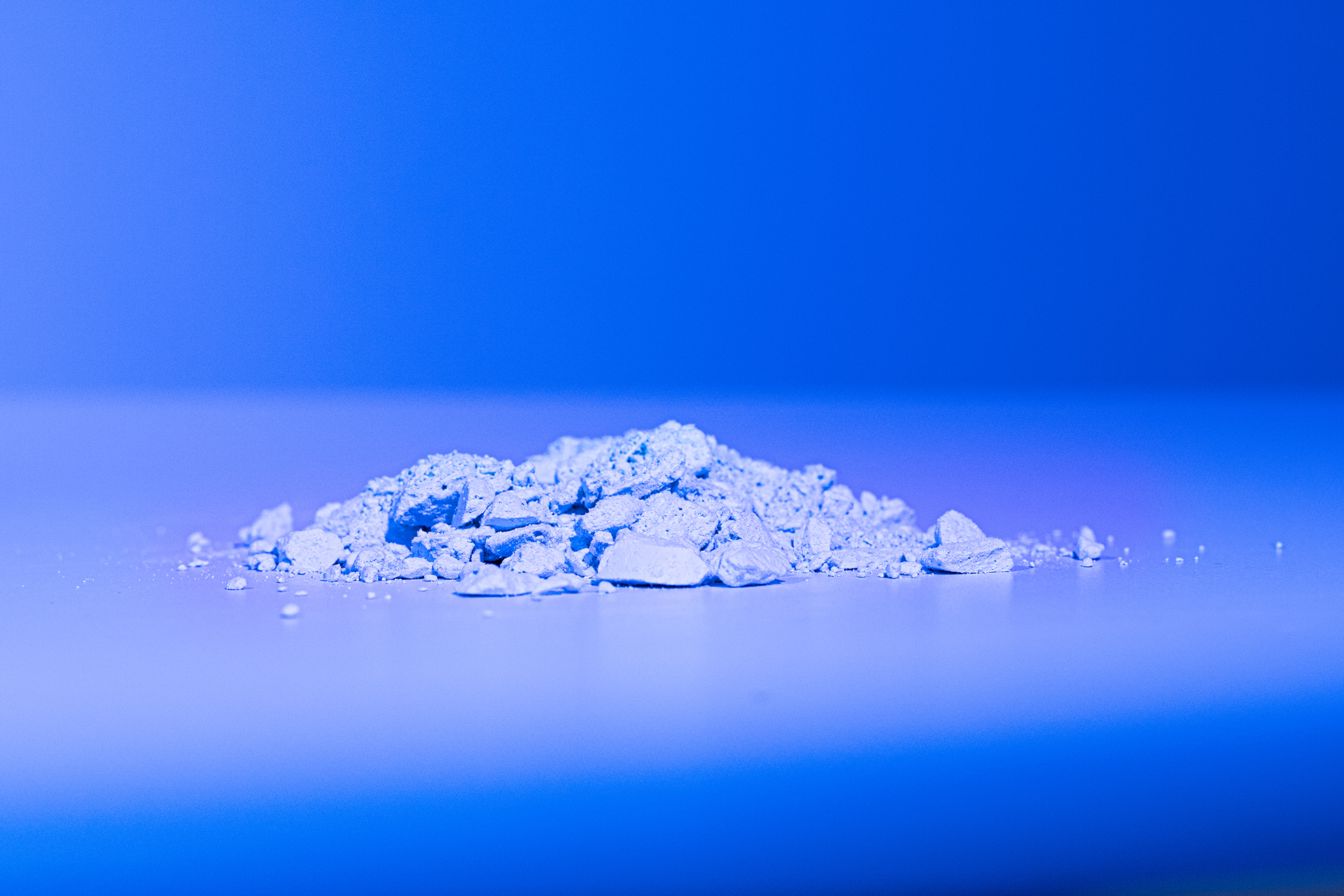 Symbolbild: Brocken einer festen Substanz vor blauem Hintergrund