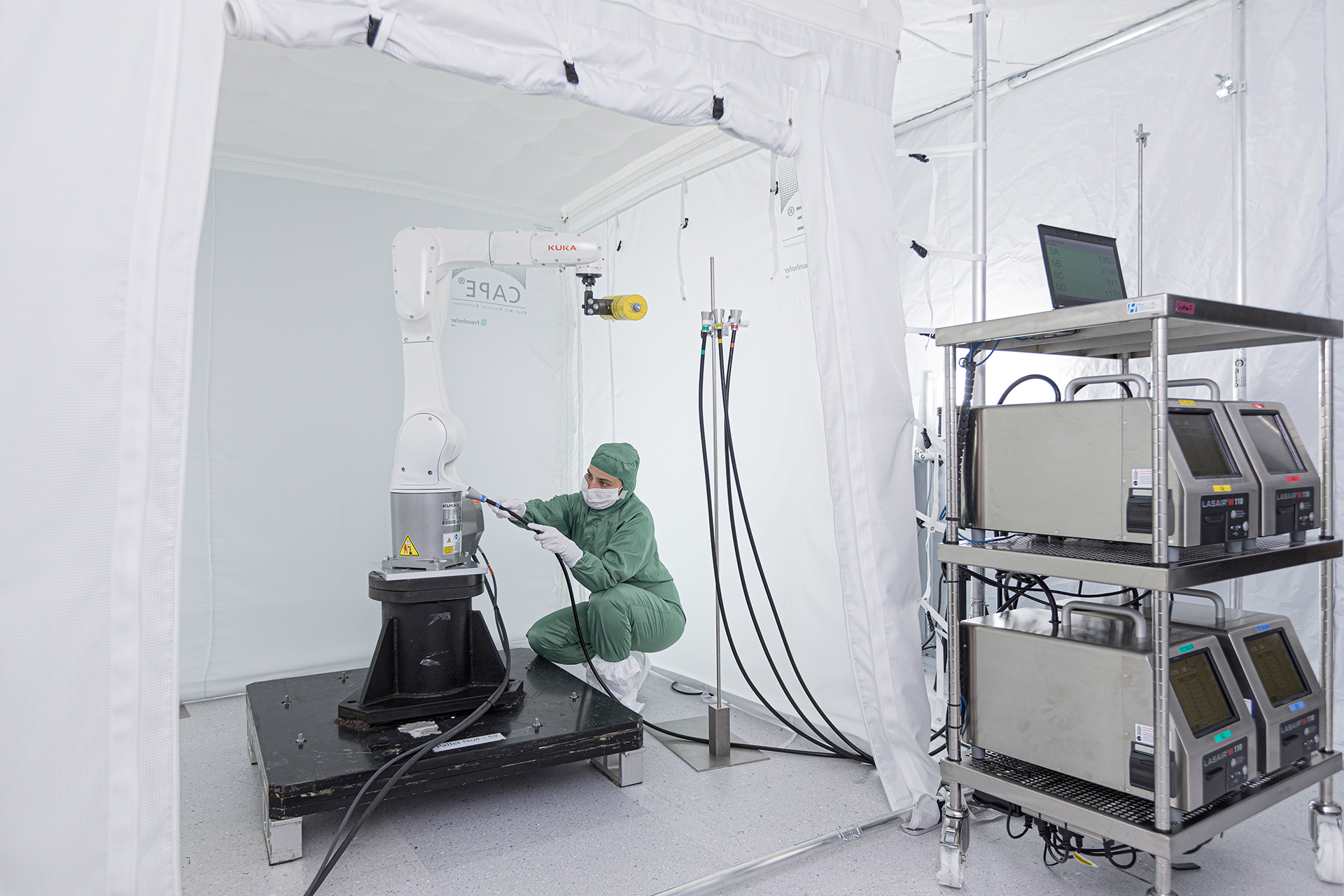 Mitarbeiterin prüft Reinraumtauglichkeit eines Roboters