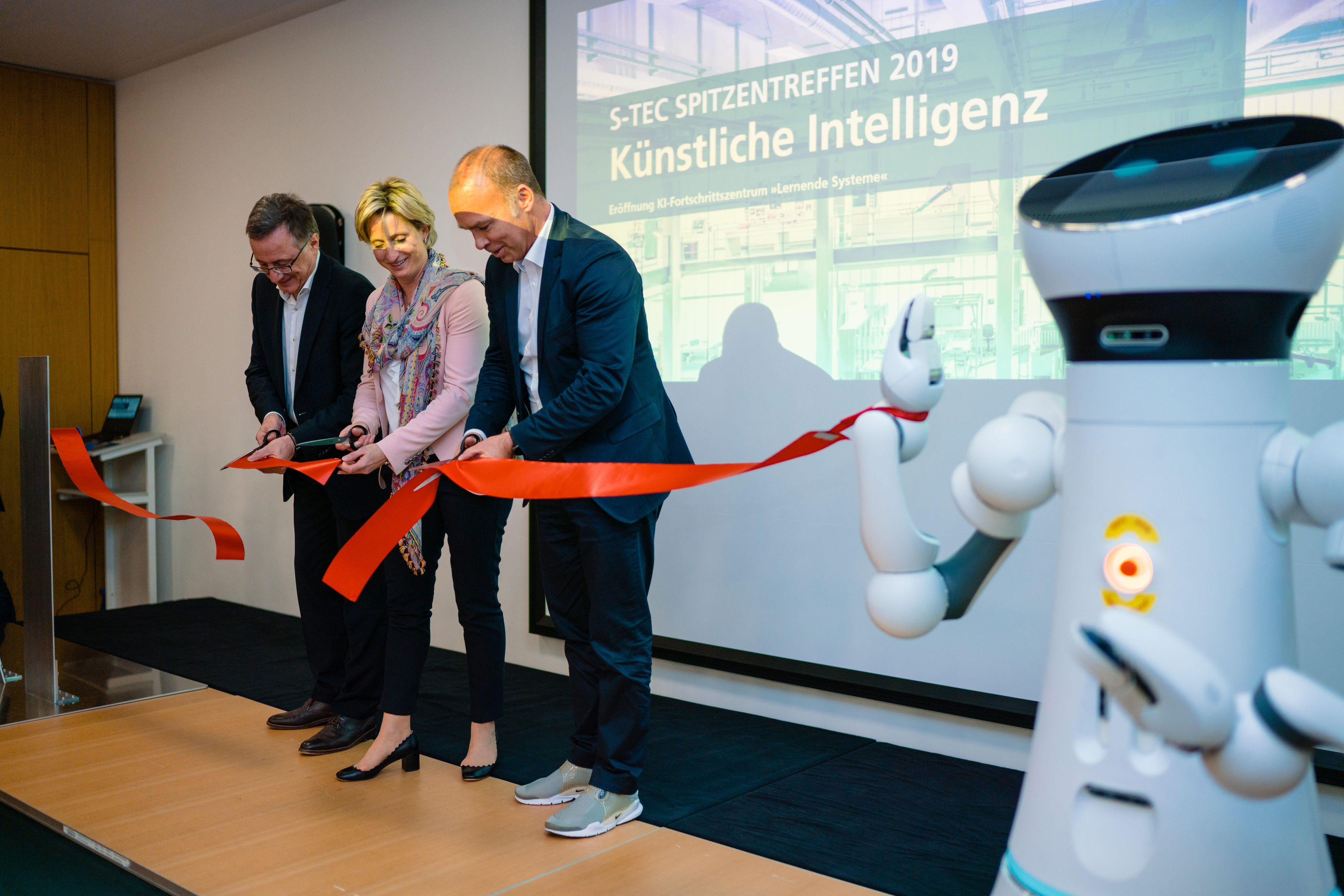 Prof. Wilhelm Bauer, Head of Fraunhofer IAO, Baden-Württemberg&#39;s Economics Minister Dr. Nicole Hoffmeister-Kraut, Prof. Thomas Bauernhansl, Head of Fraunhofer IPA, and Care-O-bot 4 open the AI Innovation Center &quot;Learning Systems&quot;.